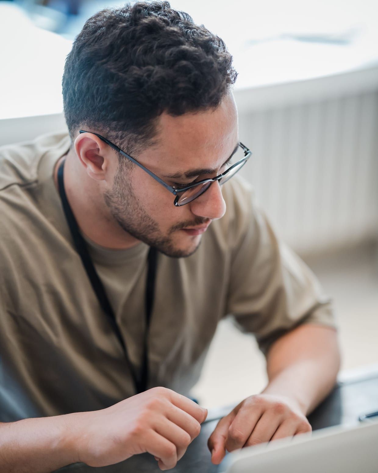 Ein Techniker prüft mit dem Notebook die Geräte in einem Netzwerkschrank