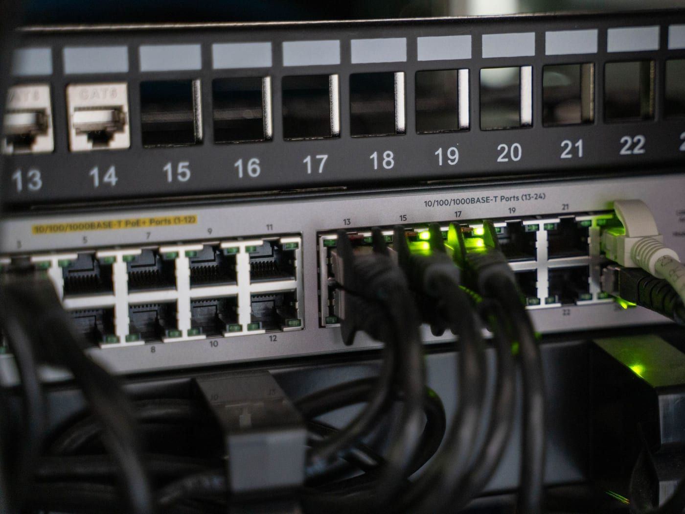 Aufgeräumter Netzwerkschrank mit beschrifteten Kabeln und Switch